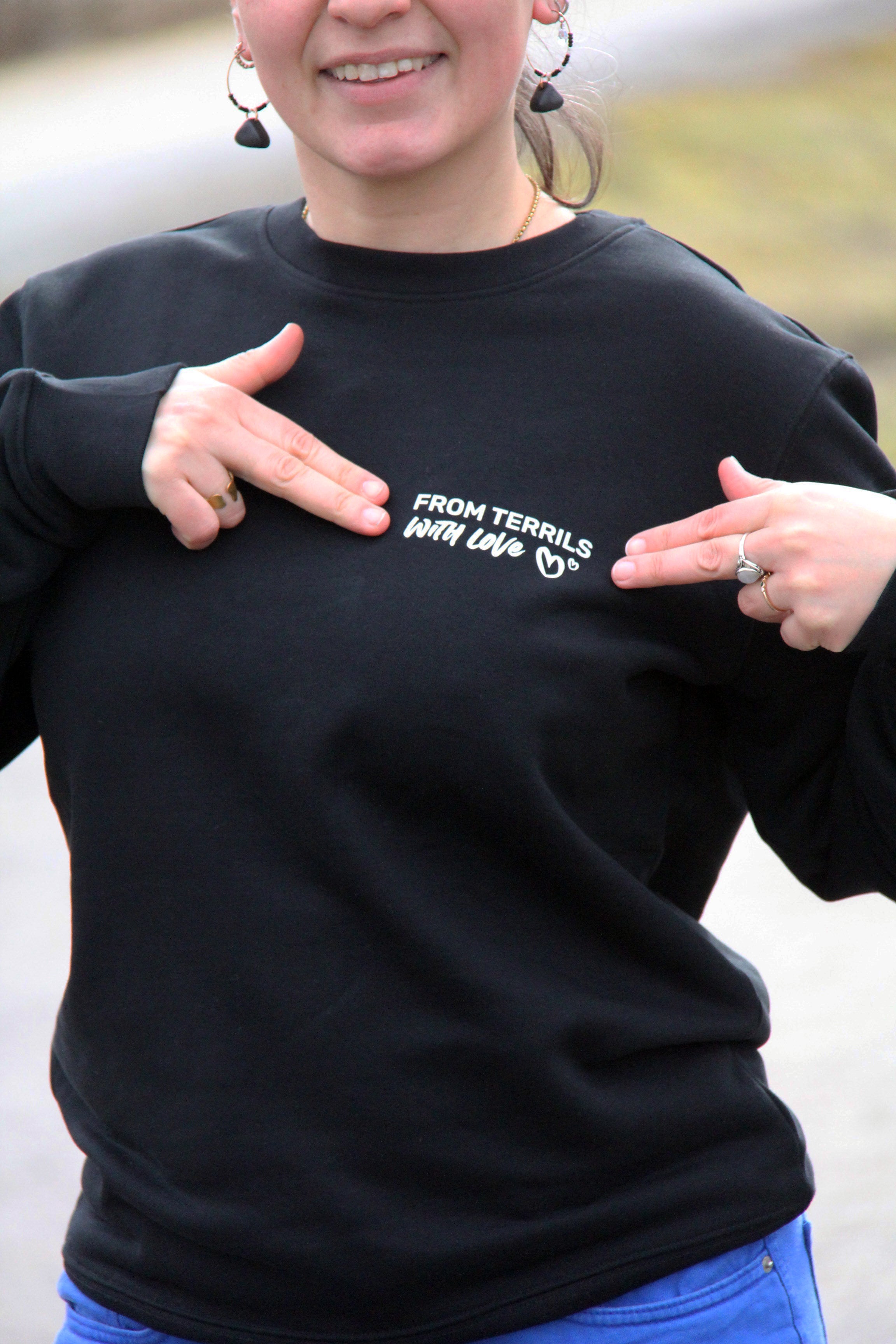 Détail du logo poitrine « From terrils with love » sur sweatshirt unisexe noir, impression blanche côté cœur
