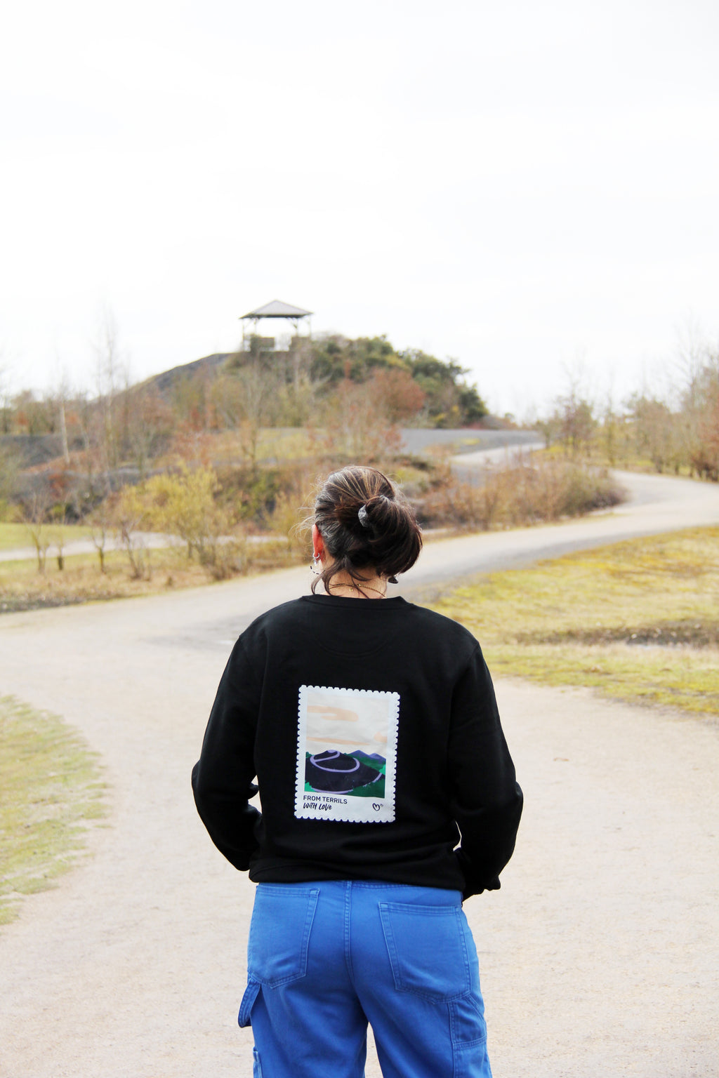 Sweatshirt unisexe noir « From terrils with love » porté de dos, illustration terril imprimée dans le dos, porté en extérieur