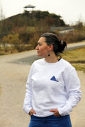 Sweatshirt unisexe blanc Patrimoine minier porté de face, petit visuel terril bleu sur la poitrine