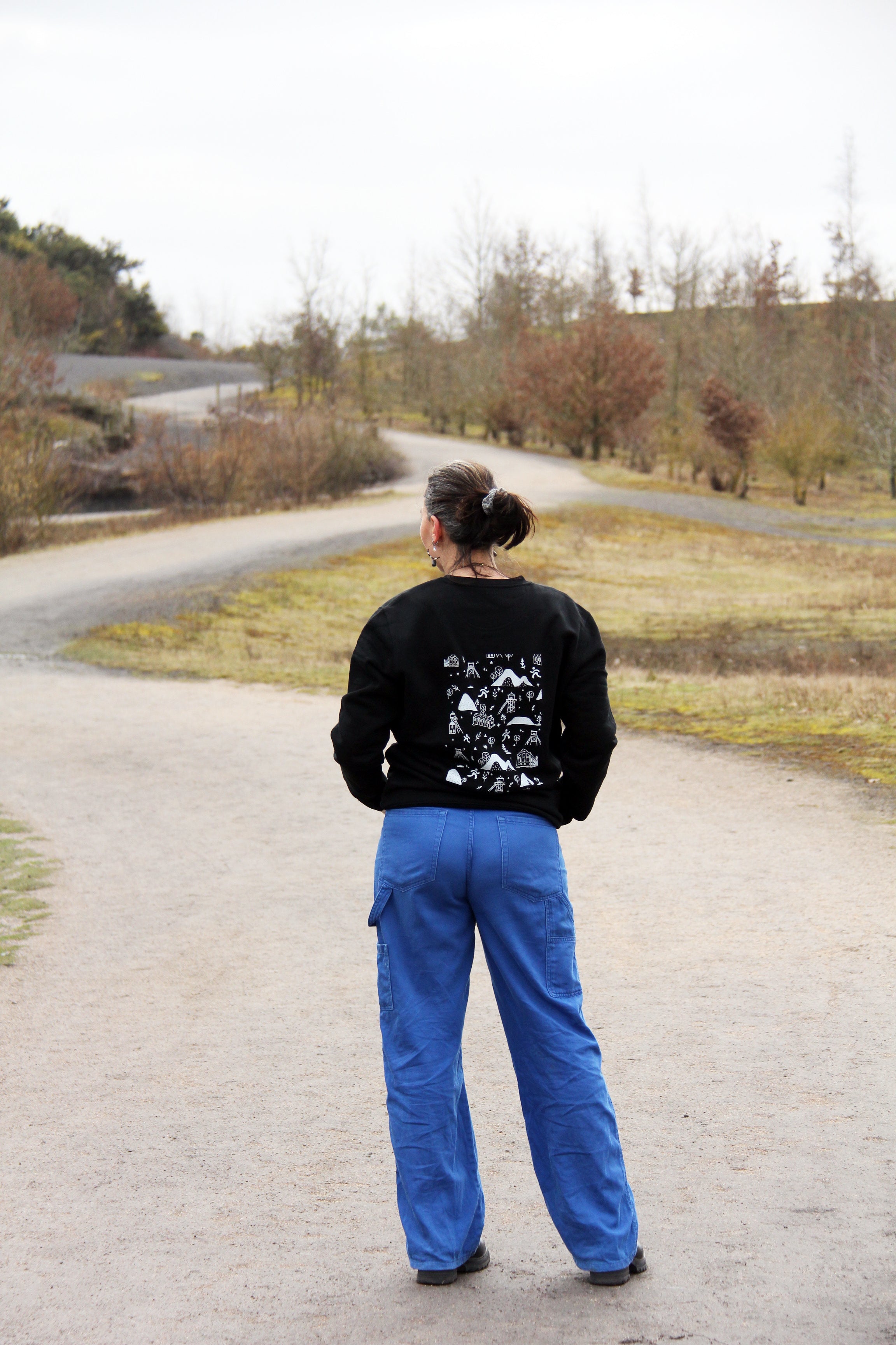 Sweatshirt unisexe noir Patrimoine minier porté de dos, grande illustration blanche du bassin minier