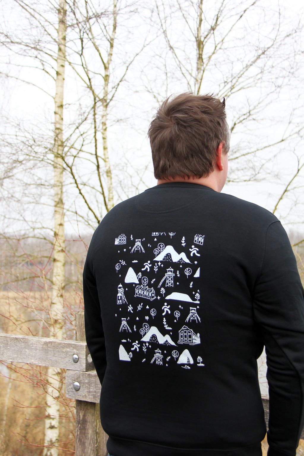 Sweatshirt unisexe noir Patrimoine minier porté de dos, motifs terrils et chevalements imprimés