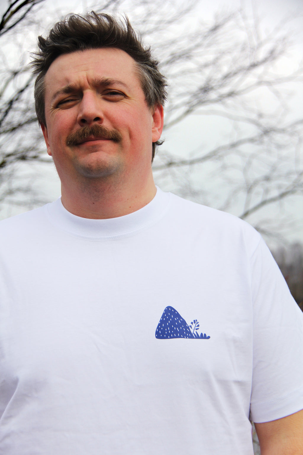 T-shirt unisexe blanc patrimoine minier porté de face, logo terril bleu imprimé sur la poitrine