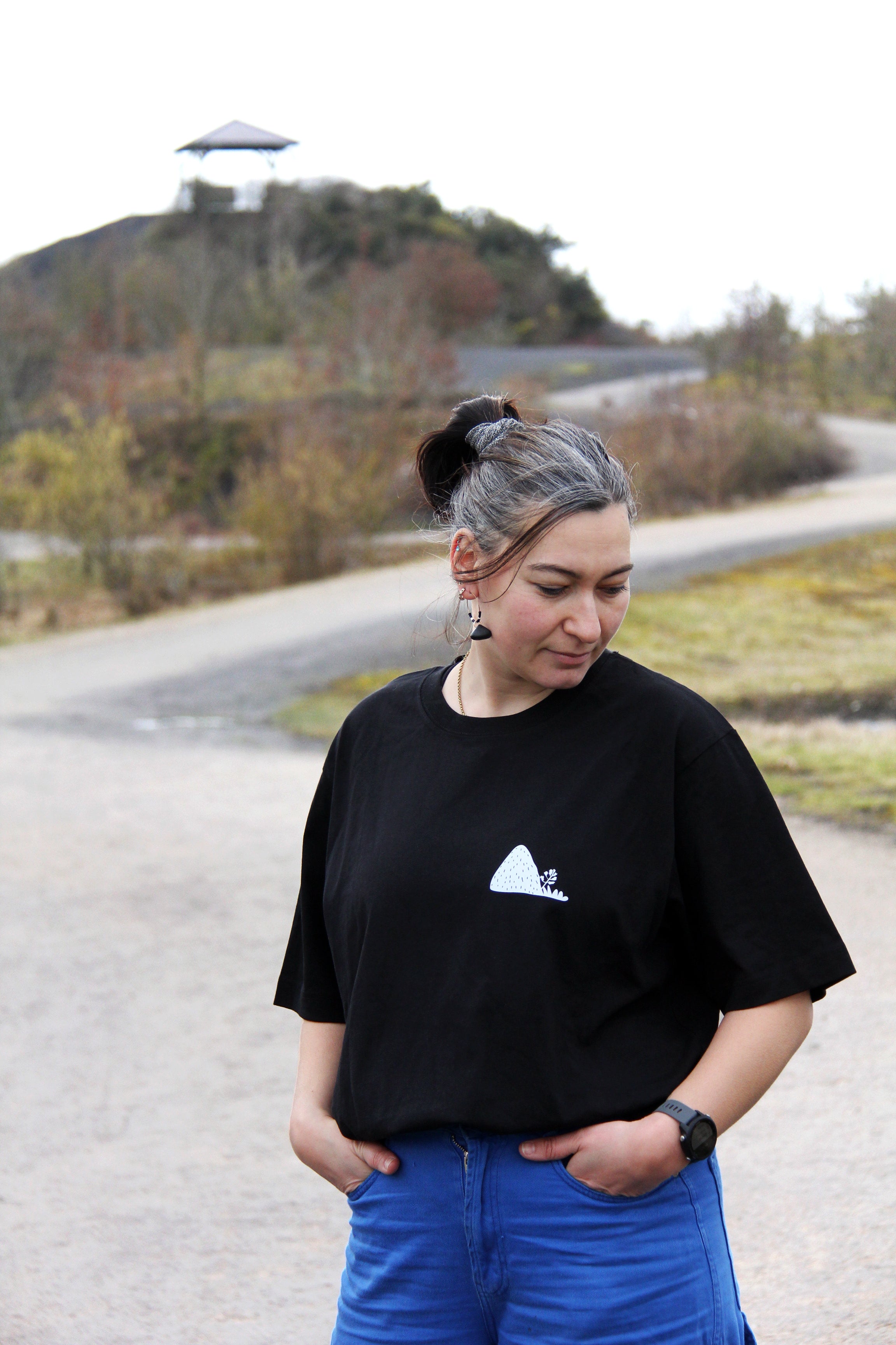 T-shirt unisexe noir patrimoine minier porté de face, petit logo terril blanc sur la poitrine