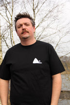 T-shirt unisexe noir patrimoine minier porté de face, logo terril blanc imprimé sur la poitrine